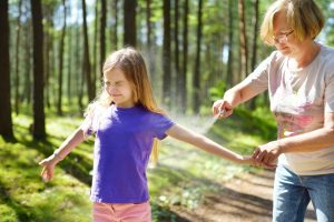 Protecting children from biting insects with repellent.