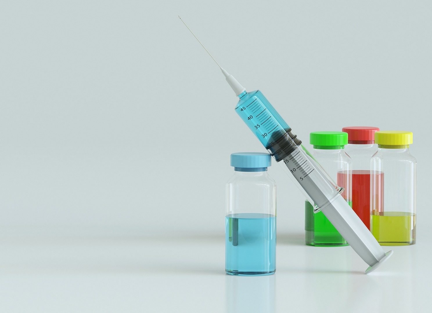 Photo of multiple colored vials with needle/syringe